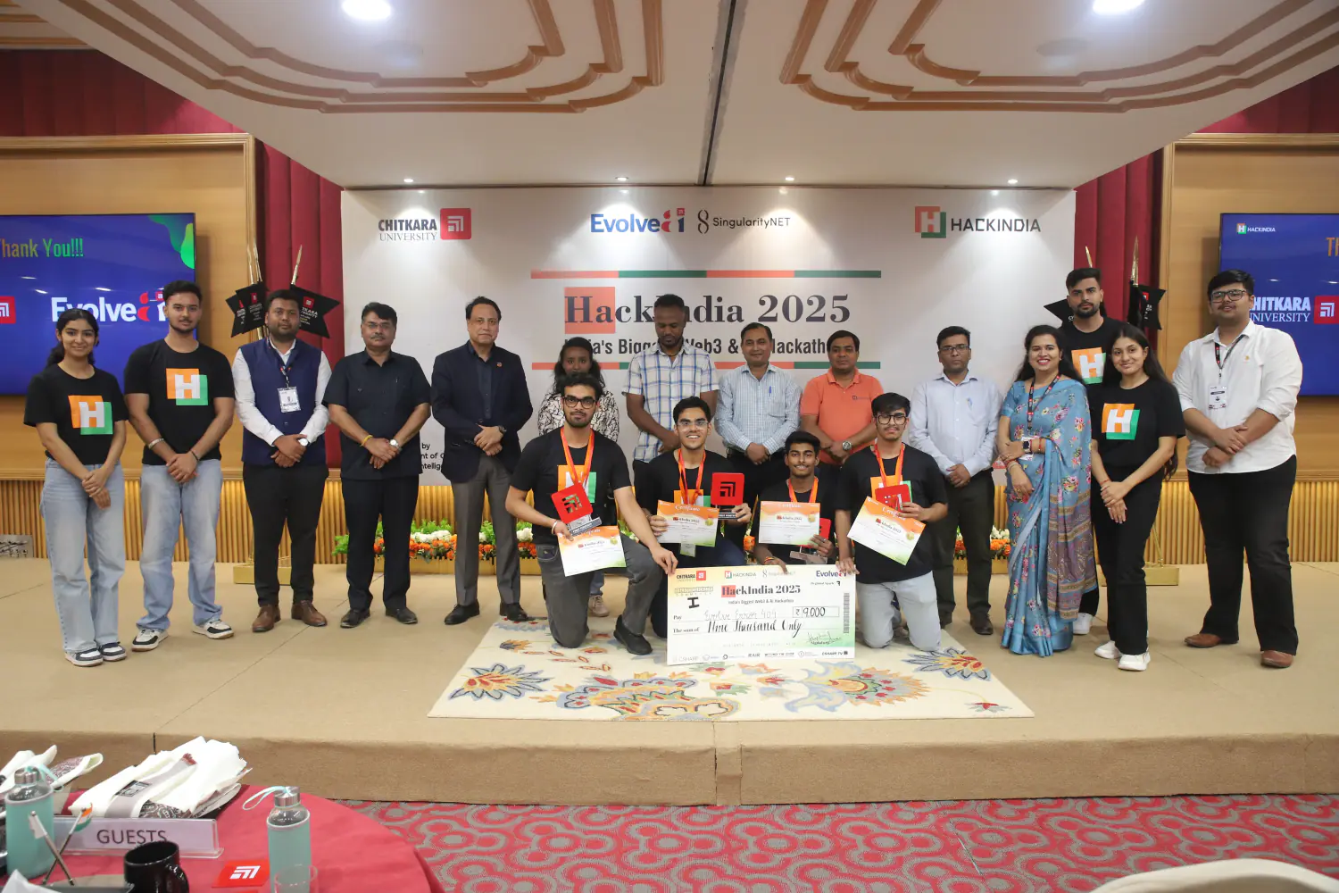 HackIndia 2025 winners on stage with their certificates and prize cheque